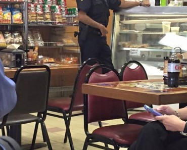 Police Officer Is Photographed While Helping A Stranger In Need In A Bakery